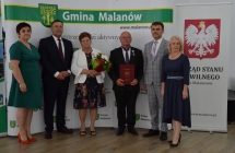 grupa osob pozuje na tle scianki z napisem gmina malanow (27)
