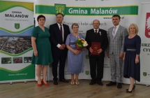 grupa osob pozuje na tle scianki z napisem gmina malanow (26)