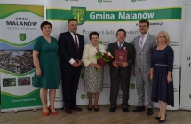 grupa osob pozuje na tle scianki z napisem gmina malanow (25)