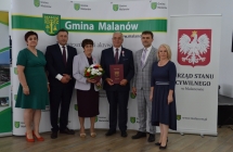 grupa osob pozuje na tle scianki z napisem gmina malanow (24)