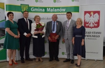 grupa osob pozuje na tle scianki z napisem gmina malanow (21)