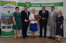 grupa osob pozuje na tle scianki z napisem gmina malanow (22)