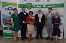 grupa osob pozuje na tle scianki z napisem gmina malanow (20)