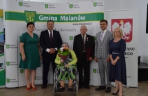 grupa osob pozuje na tle scianki z napisem gmina malanow (14)