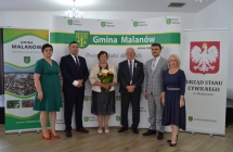 grupa osob pozuje na tle scianki z napisem gmina malanow (15)