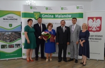 grupa osob pozuje na tle scianki z napisem gmina malanow (10)
