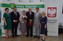 grupa osob pozuje na tle scianki z napisem gmina malanow (16)