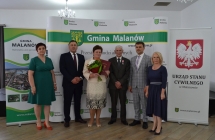 grupa osob pozuje na tle scianki z napisem gmina malanow (7)