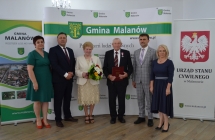 grupa osob pozuje na tle scianki z napisem gmina malanow (12)