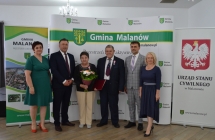 grupa osob pozuje na tle scianki z napisem gmina malanow (13)