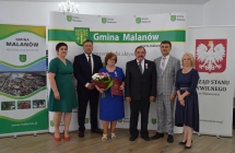 grupa osob pozuje na tle scianki z napisem gmina malanow (9)