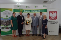 grupa osob pozuje na tle scianki z napisem gmina malanow (4)