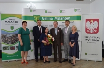 grupa osob pozuje na tle scianki z napisem gmina malanow (6)