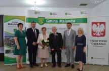 grupa osob pozuje na tle scianki z napisem gmina malanow (5)