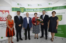 grupa osob stoi na tle scianki z napismi