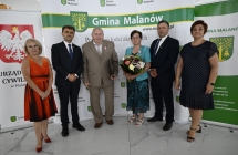 grupa osob stoi na tle scianki z napismi    